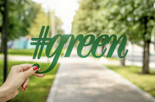 Woman Holding #green Up Against a Park Background